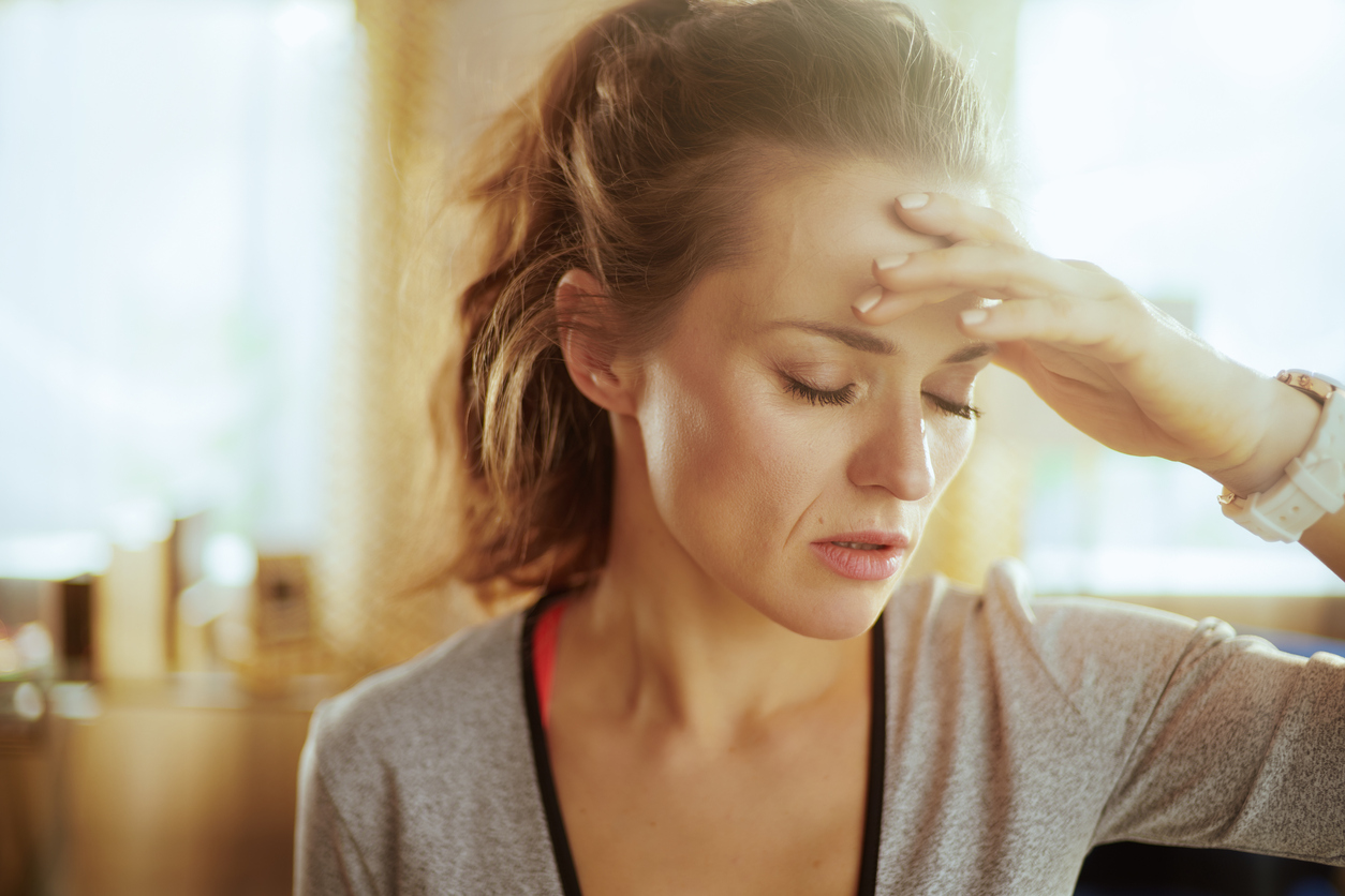 stressed healthy sports woman in sport clothes at modern home